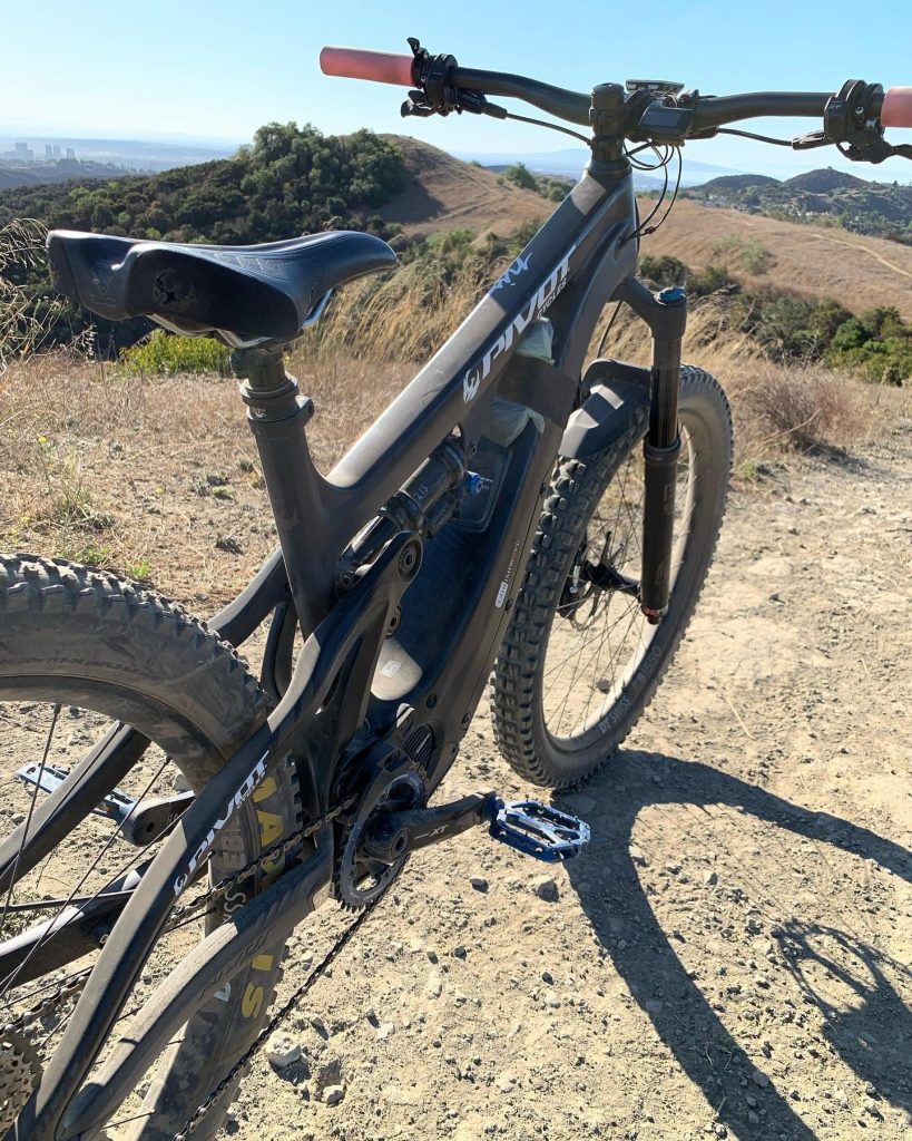 A premium Pivot electric mountain bike tuned for optimal performance on a rugged hillside trail.